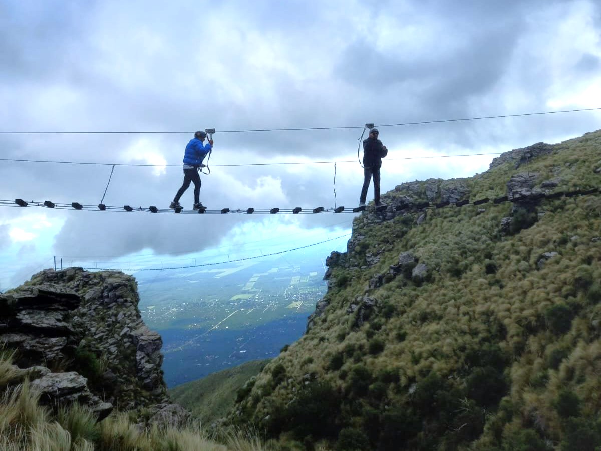 Turistas realizando actividades de aventura en Merlo San Luis con las sierras de fondo.